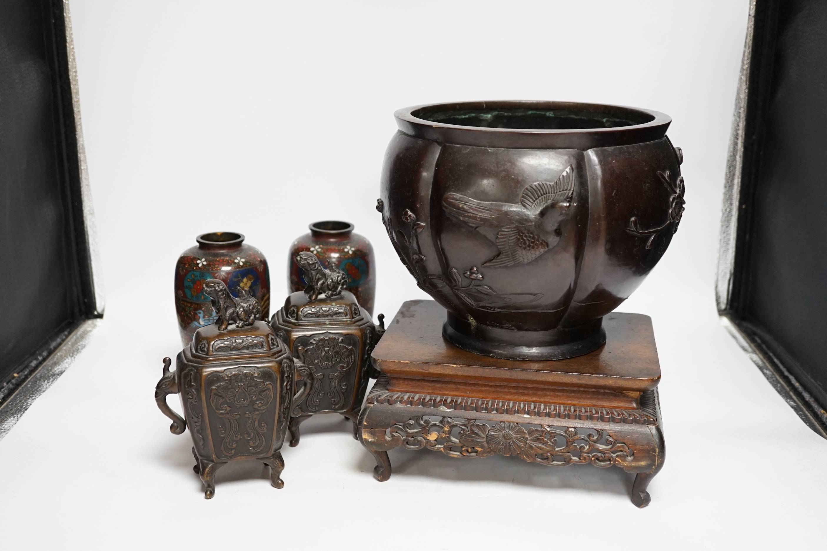 A Meiji period Japanese bronze jardiniere, a pair of cloisonné vases, a hardwood stand, etc.